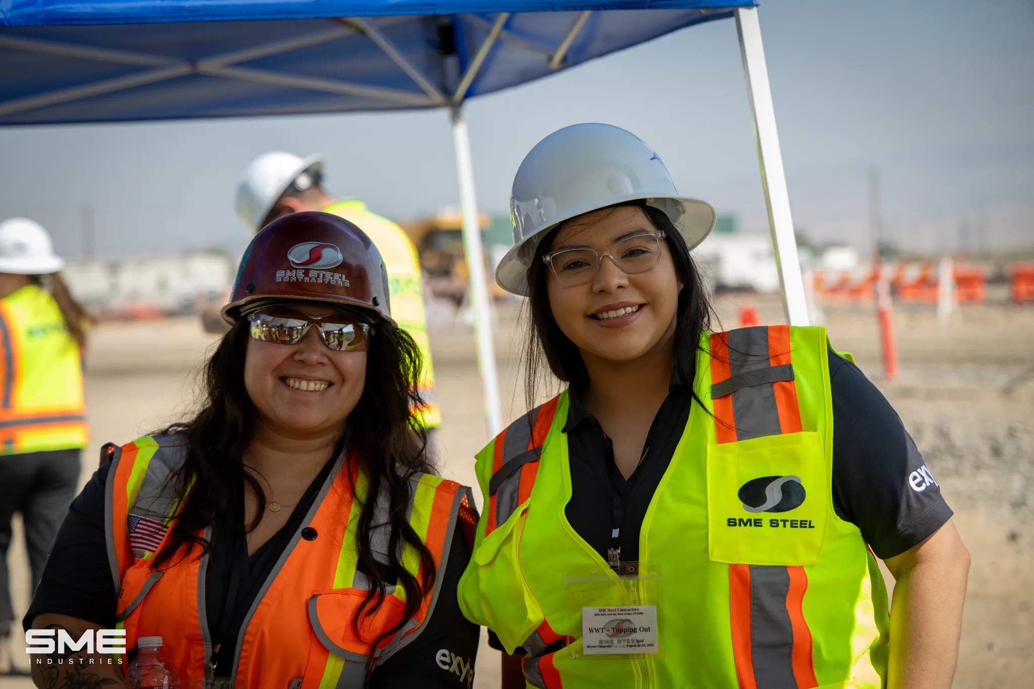 Two women in hard hats and safety vests