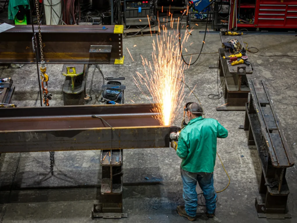 Man cutting steel beam in a work shop